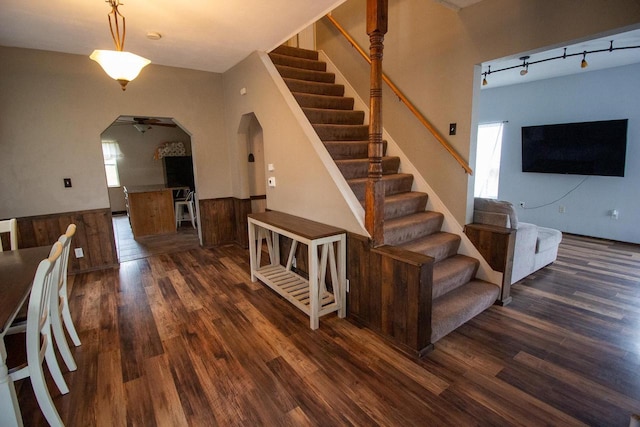 stairs featuring hardwood / wood-style floors, rail lighting, and ceiling fan