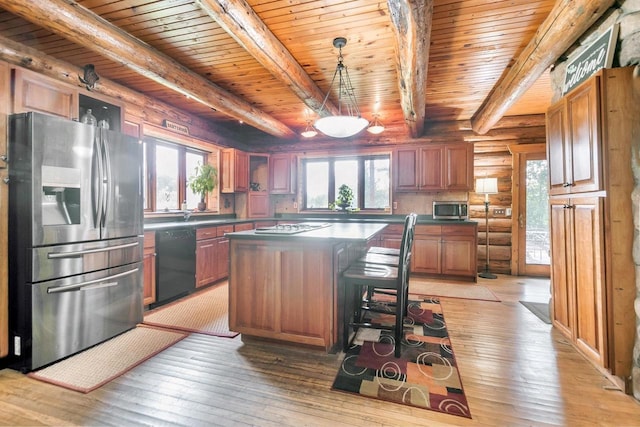 kitchen featuring stainless steel appliances, a wealth of natural light, light hardwood / wood-style floors, and a center island