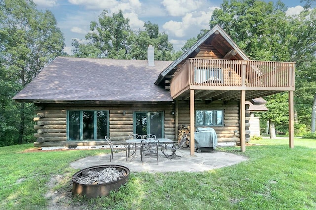 back of house with a wooden deck, an outdoor fire pit, a patio, and a yard