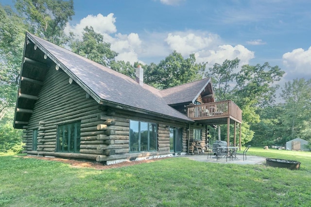 rear view of house featuring a shed, a lawn, and a patio area