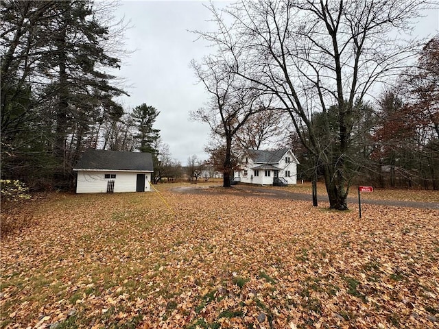 view of yard featuring a garage and an outbuilding