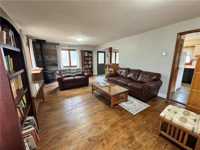 living room featuring dark hardwood / wood-style floors, a textured ceiling, and a wood stove