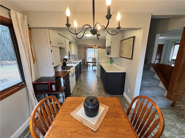 dining area with a notable chandelier, a textured ceiling, and sink