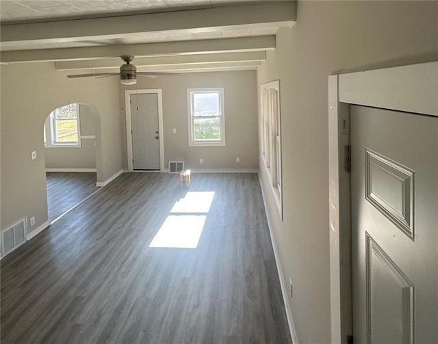 unfurnished living room featuring ceiling fan, dark hardwood / wood-style floors, and beamed ceiling