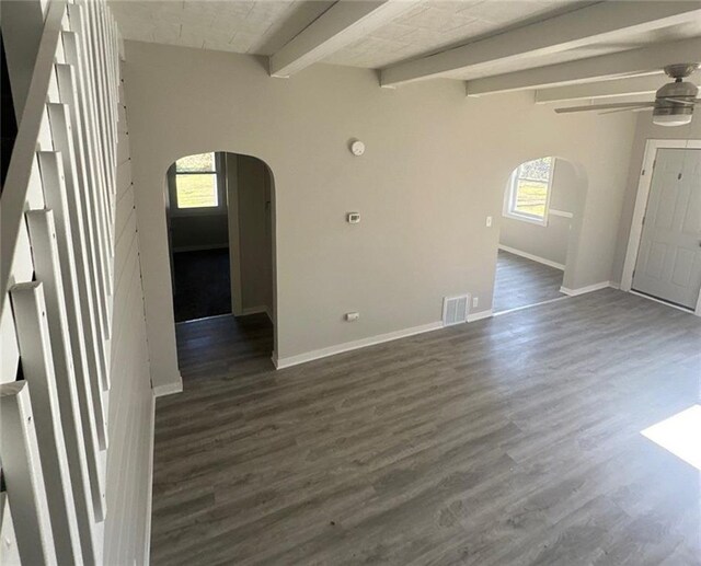 6970 Second St, Loretta, WI 54896 - unfurnished room featuring arched walkways, a ceiling fan, baseboards, dark wood-type flooring, and beam ceiling