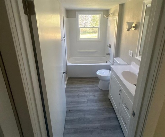 full bathroom with hardwood / wood-style flooring, vanity, toilet, and shower / bath combination