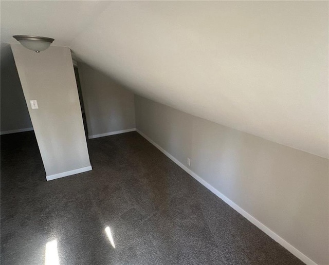 6970 Second St, Loretta, WI 54896 - bonus room with vaulted ceiling, baseboards, and dark colored carpet