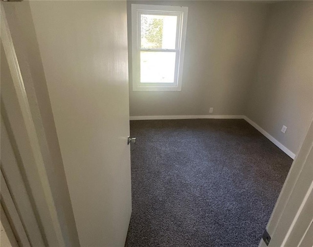 empty room with dark colored carpet