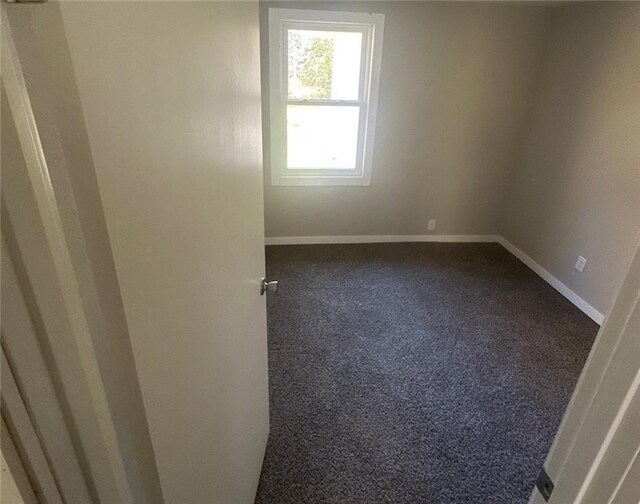 6970 Second St, Loretta, WI 54896 - empty room featuring dark colored carpet and baseboards