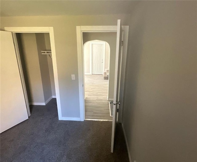 unfurnished bedroom with a closet and dark carpet