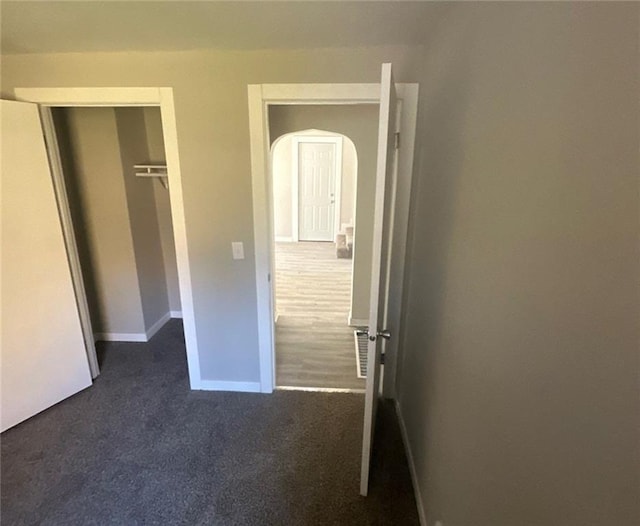 6970 Second St, Loretta, WI 54896 - unfurnished bedroom featuring arched walkways, dark colored carpet, baseboards, and a closet