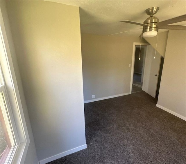 6970 Second St, Loretta, WI 54896 - unfurnished room with dark colored carpet, ceiling fan, and baseboards