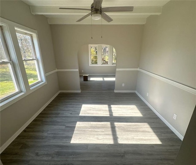 empty room featuring dark hardwood / wood-style flooring, ceiling fan, and beam ceiling