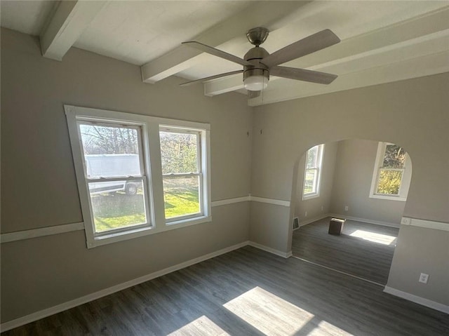 spare room with beamed ceiling, plenty of natural light, and dark hardwood / wood-style flooring