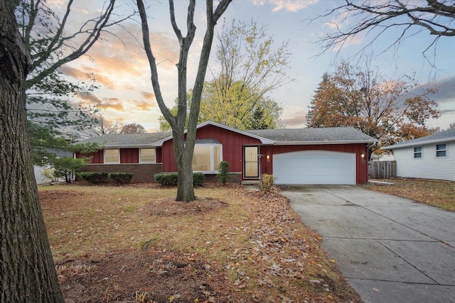 ranch-style house with a garage and a lawn