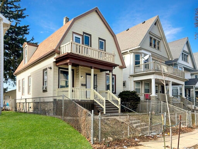 view of front of house with a front lawn, a balcony, cooling unit, and a porch