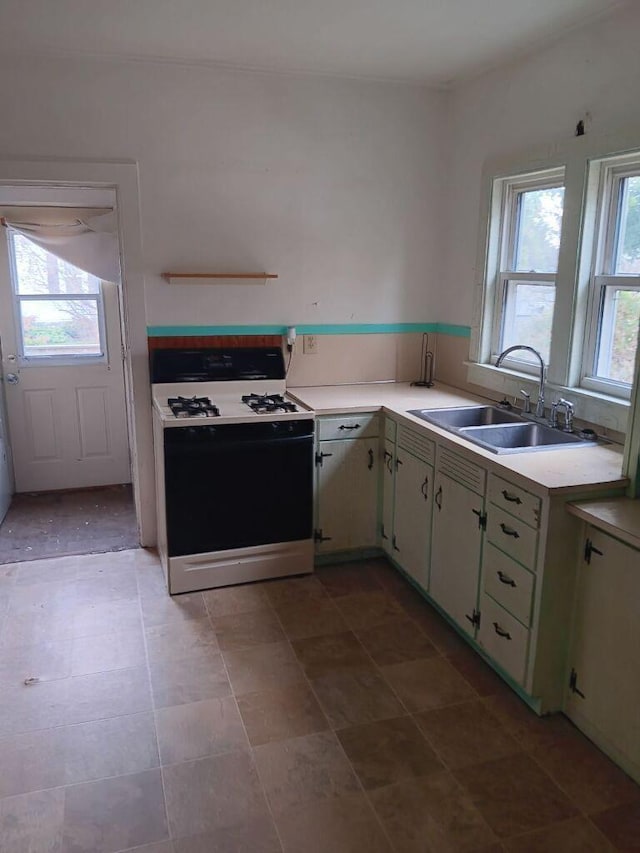 kitchen featuring a healthy amount of sunlight, sink, and white gas range oven