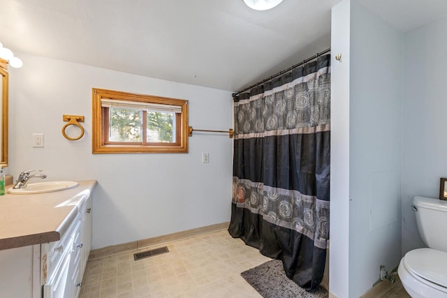 bathroom featuring toilet, vanity, and walk in shower