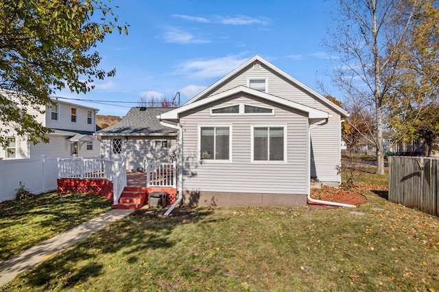 back of house featuring a wooden deck and a yard