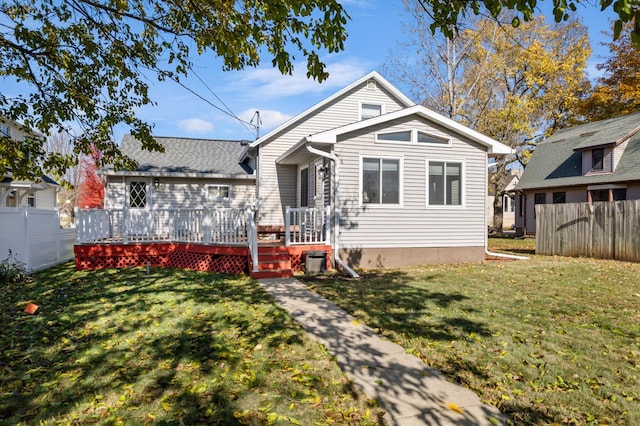 bungalow-style home with a front yard and a wooden deck