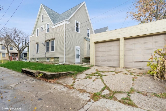 view of side of property with a garage and a yard