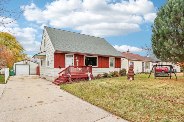 view of front of home with a front lawn, a garage, and an outbuilding