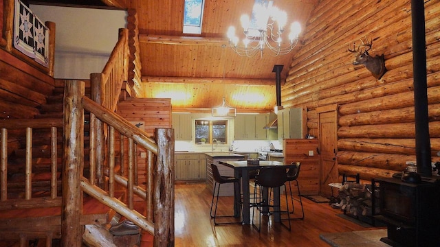 dining room featuring hardwood / wood-style flooring, sink, log walls, lofted ceiling, and a notable chandelier