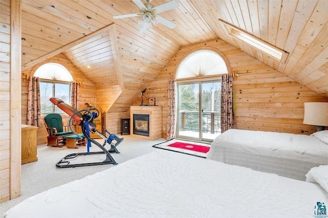 carpeted bedroom featuring wooden ceiling, wooden walls, and lofted ceiling with skylight