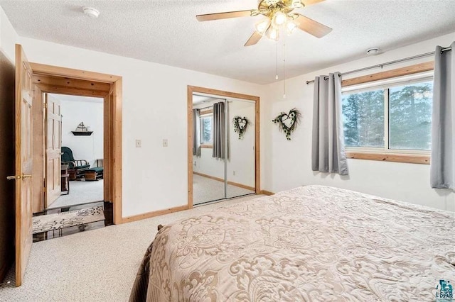 carpeted bedroom featuring ceiling fan, a textured ceiling, and a closet