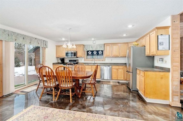 kitchen with sink, appliances with stainless steel finishes, light brown cabinetry, a textured ceiling, and pendant lighting