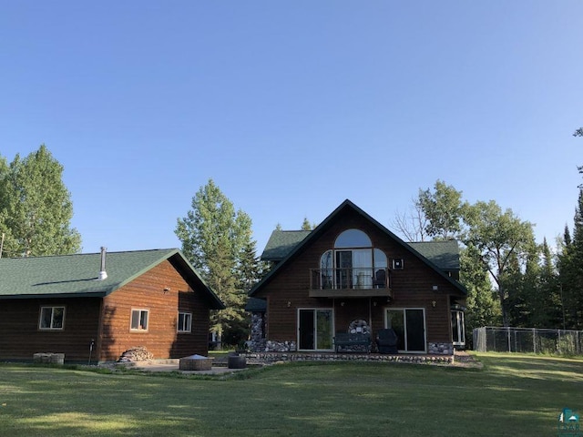 rear view of property with a balcony, a yard, and a patio area