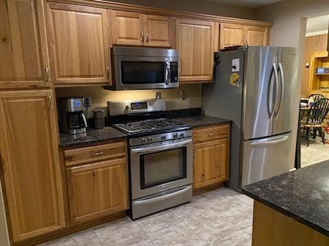 kitchen featuring dark stone counters and appliances with stainless steel finishes