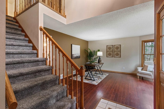 stairs featuring hardwood / wood-style floors and a textured ceiling