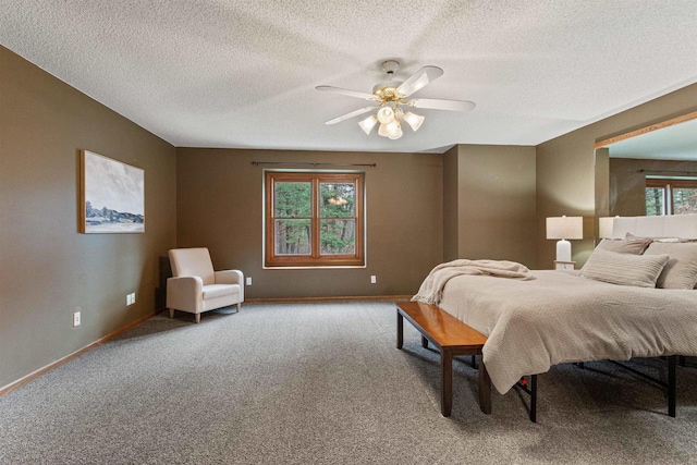 bedroom featuring ceiling fan, multiple windows, carpet flooring, and a textured ceiling