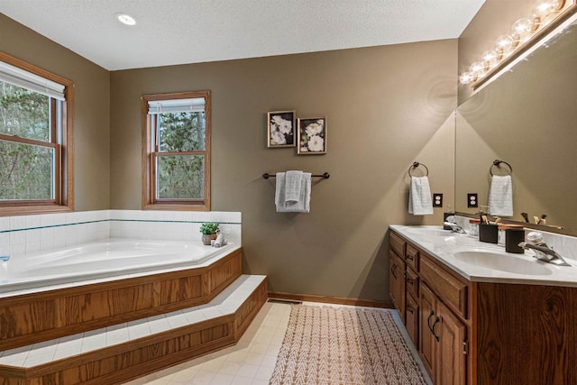 bathroom featuring vanity, a tub to relax in, and a textured ceiling