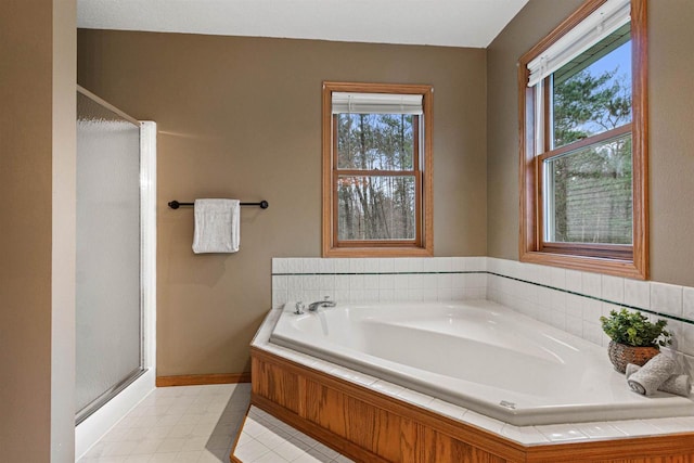 bathroom with shower with separate bathtub and a wealth of natural light