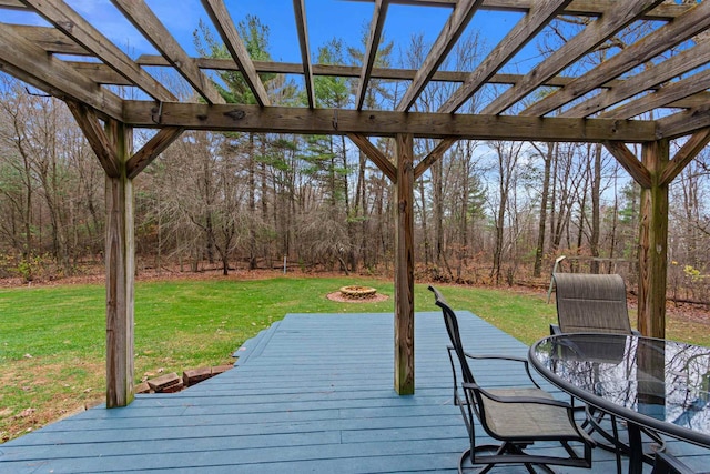 wooden deck featuring a fire pit, a pergola, and a lawn