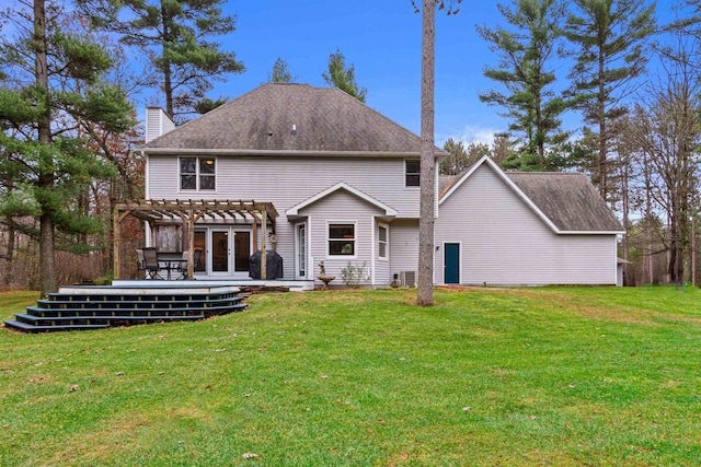 rear view of property featuring a pergola, a yard, and a wooden deck