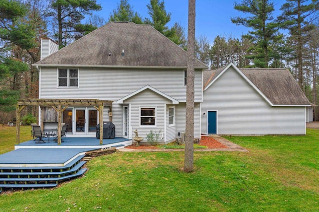 rear view of house with a deck and a yard