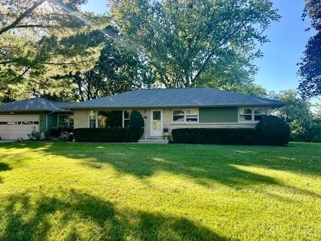 ranch-style house with a garage and a front yard