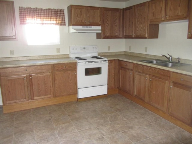 732 Chippewa St, Eau Claire, WI 54703 - kitchen with white electric range oven, under cabinet range hood, a sink, brown cabinets, and light countertops