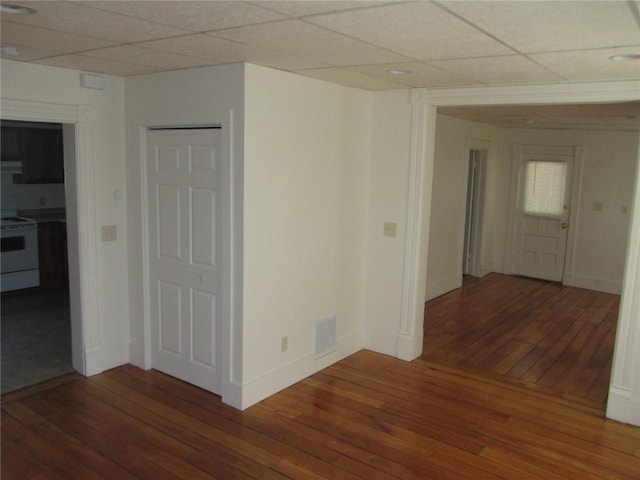 unfurnished room featuring a paneled ceiling and dark hardwood / wood-style floors