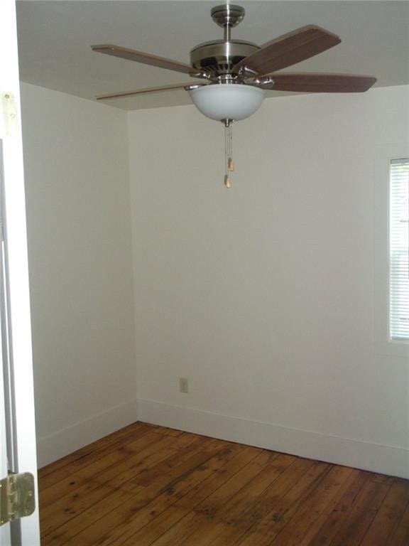 unfurnished room with dark wood-type flooring and ceiling fan