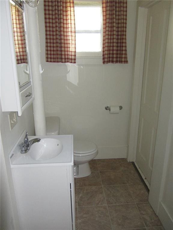 bathroom with tile patterned flooring, vanity, and toilet