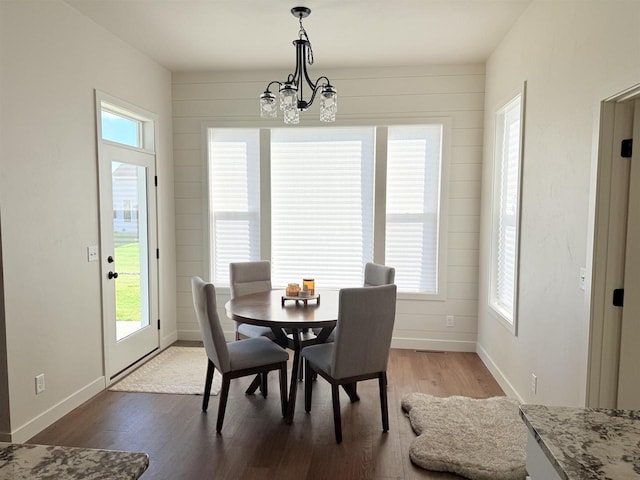 dining space featuring hardwood / wood-style flooring and a chandelier