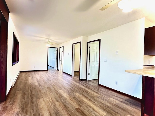 unfurnished living room featuring a baseboard radiator, hardwood / wood-style flooring, and ceiling fan