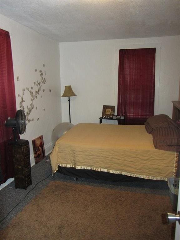 bedroom featuring a textured ceiling and carpet floors