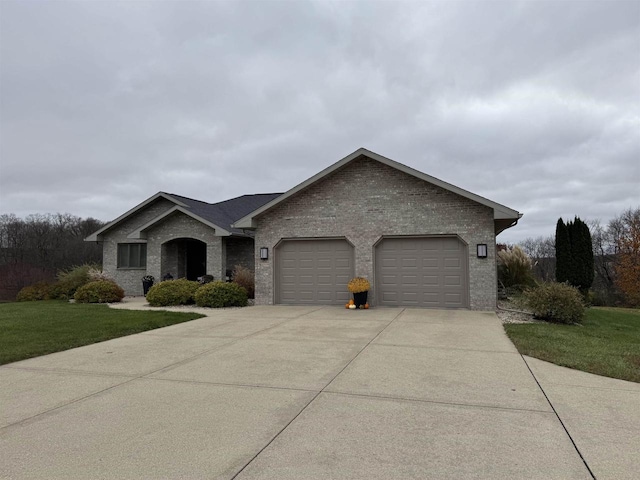 ranch-style house featuring a garage and a front lawn