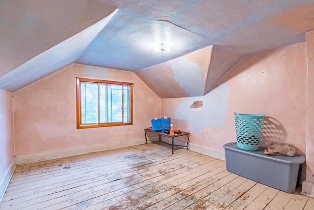 bonus room featuring light wood-type flooring and lofted ceiling