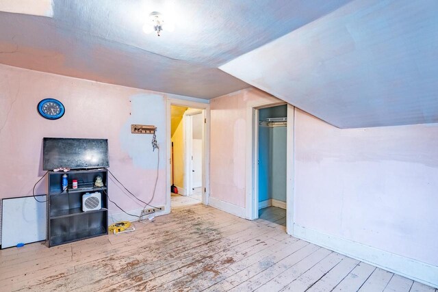 bonus room with light hardwood / wood-style floors and vaulted ceiling